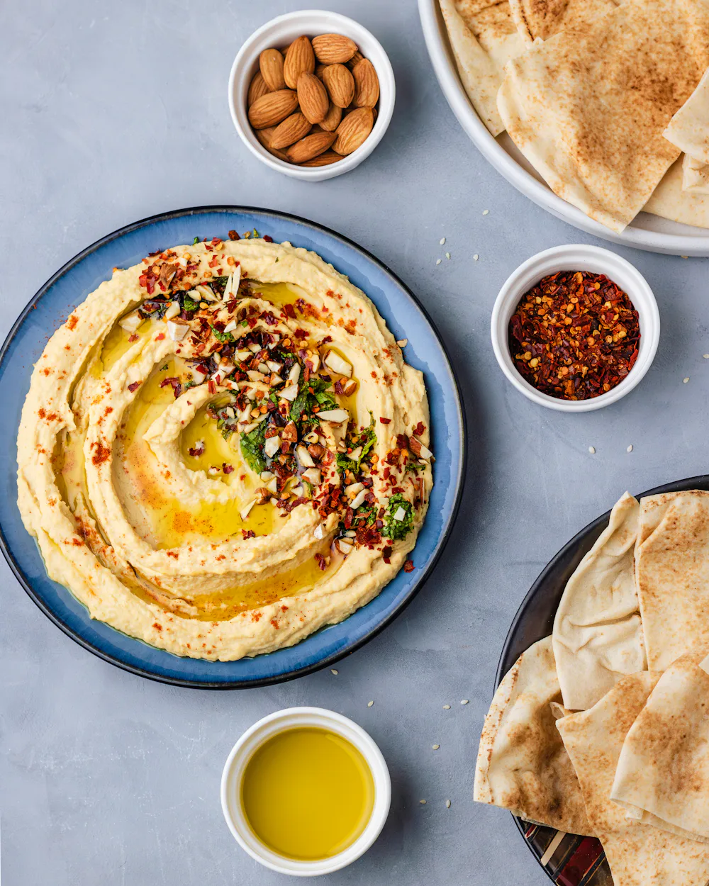 Hummus mit Olivenöl und Gewürzen, dazu Fladenbrot