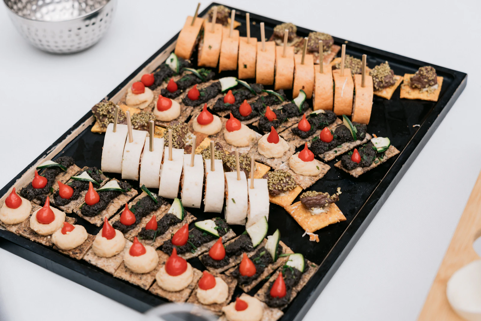 Tablett mit Fingerfood: belegte Cracker und Wraps